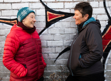 two ladies talking by a wall